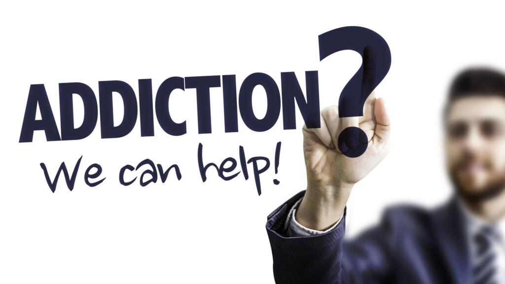 Hand writing "Addiction? We can help!" on clear screen, alcohol recovery