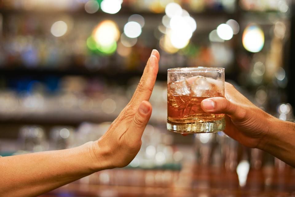 Person refusing a drink, illustrating alcohol allergy symptoms
