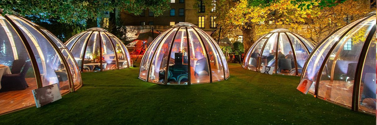 Lit-up glass domes offer cozy, alcohol free activities in a park setting.