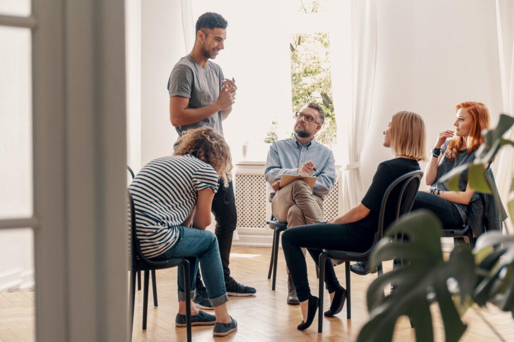 A diverse group discussing addiction recovery in a supportive circle