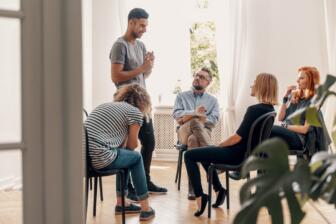 A diverse group discussing addiction recovery in a supportive circle