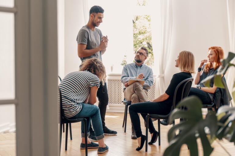 A diverse group discussing addiction recovery in a supportive circle
