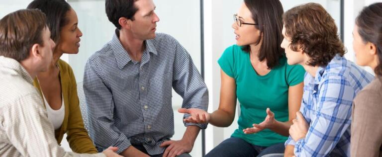 Group therapy session for alcohol recovery, people discussing support strategies.