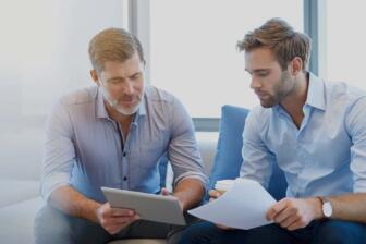 Two men discussing alcohol recovery plans in a supportive setting.