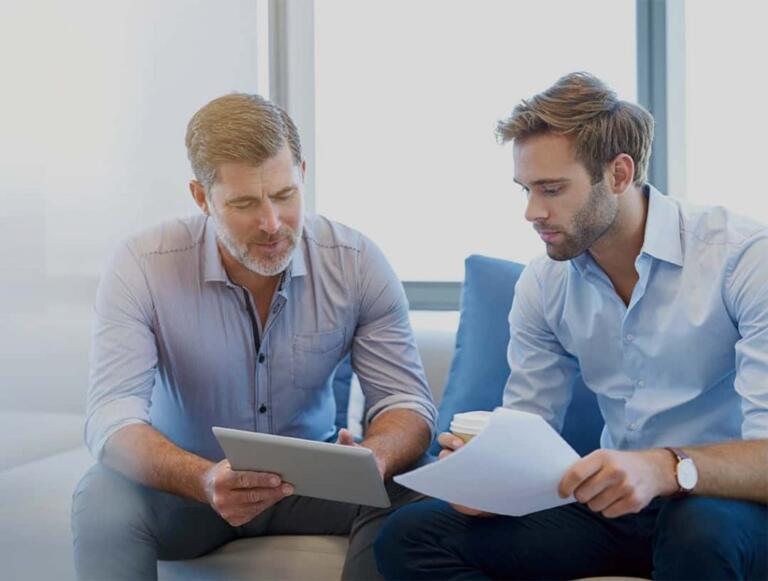 Two men discussing alcohol recovery plans in a supportive setting.