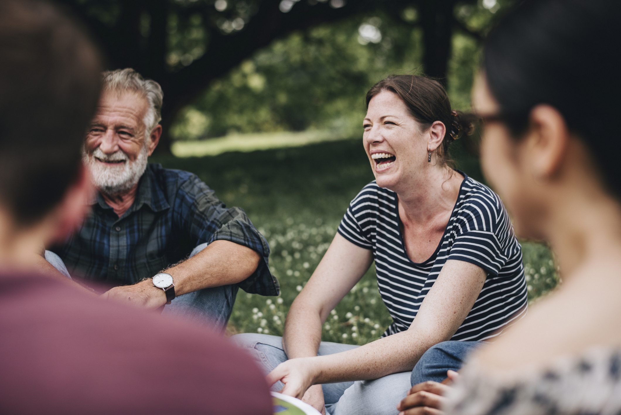 People enjoying a support group session in a park for alcohol recovery