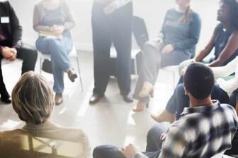Individuals in a support group meeting for alcohol recovery