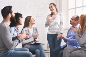 Alcohol rehab Selly Oak community in group meeting, smiling and clapping