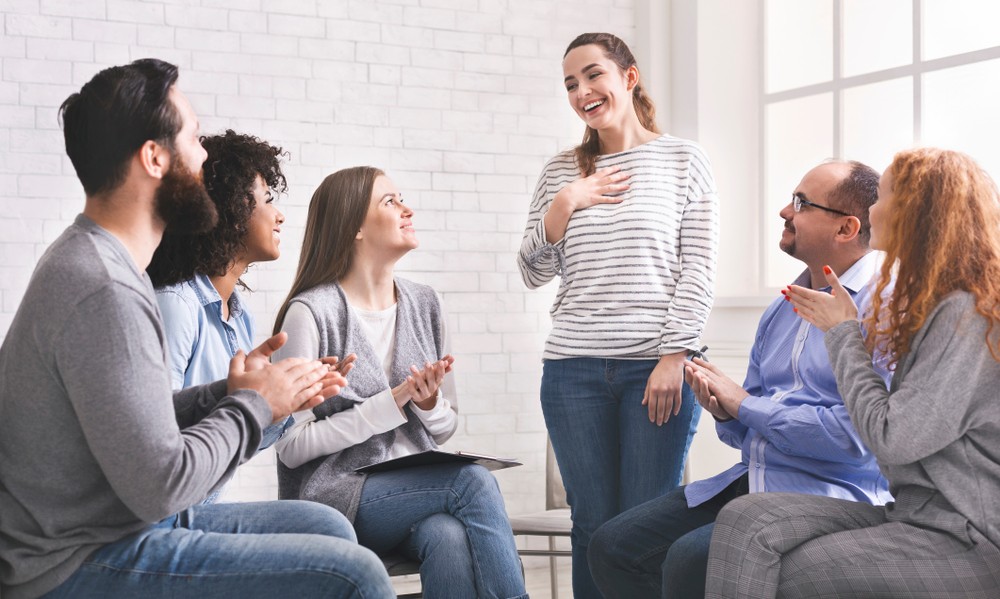 Alcohol rehab Selly Oak community in group meeting, smiling and clapping