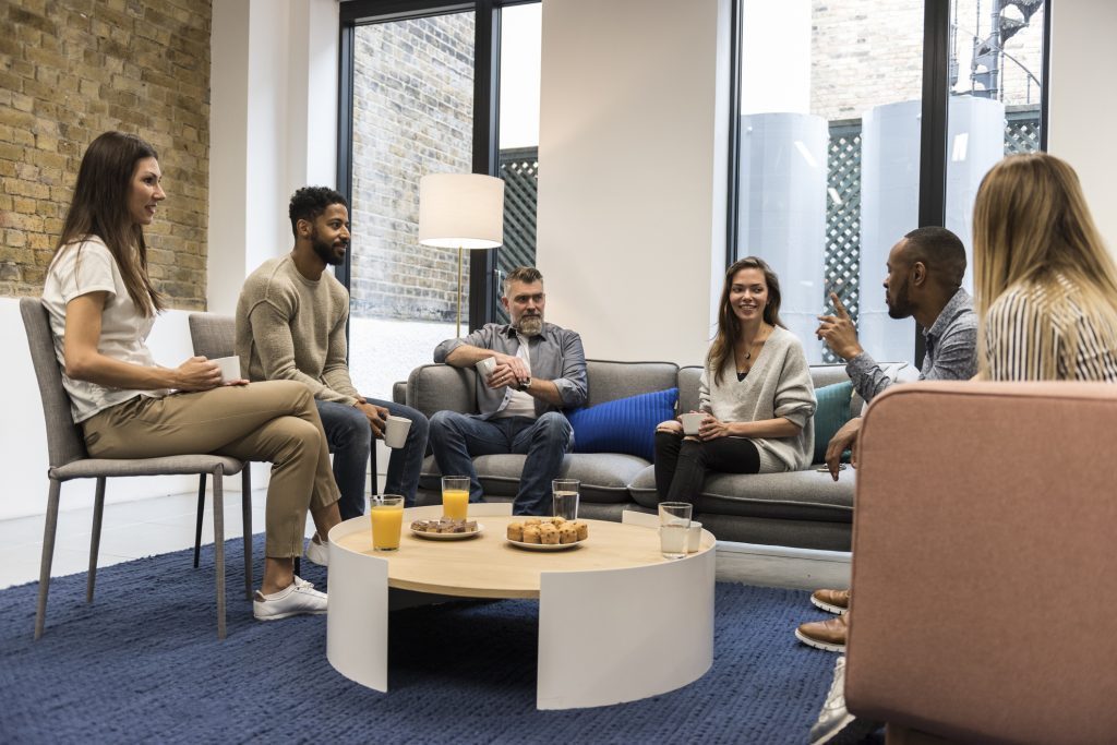 Group therapy session at alcohol rehab Sutton, people sharing experiences.