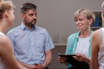 A support group discussing Alcohol Use Disorder recovery in rehab.