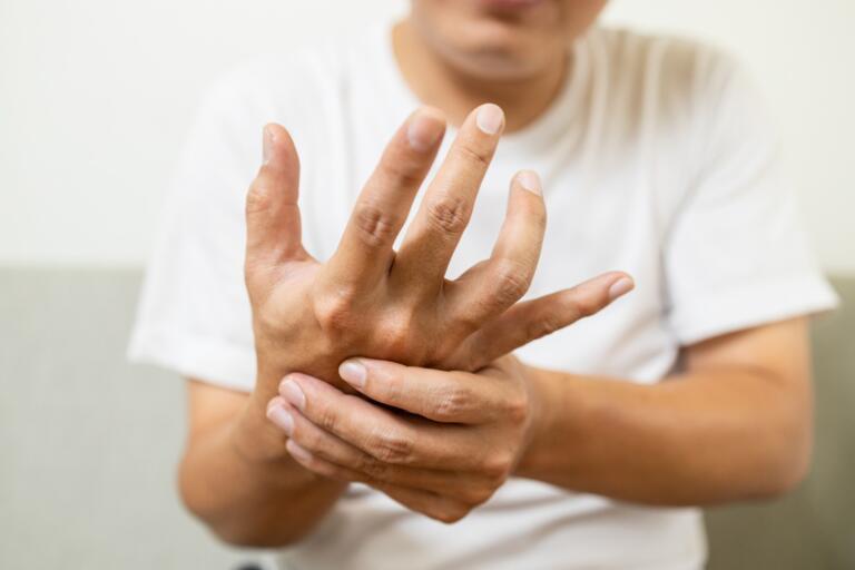Person holding hand, coping with alcohol withdrawal symptoms