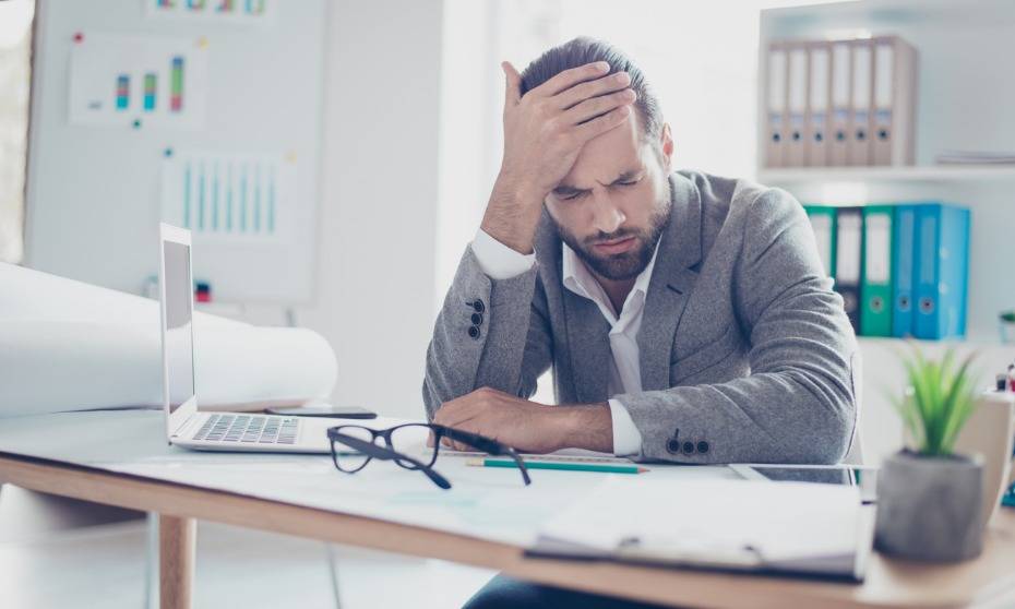 Man experiencing comedown symptoms at desk, alcohol recovery context
