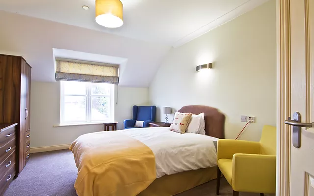 Bright rehab room with cozy bed and window for alcohol recovery