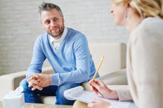 Man in therapy session for alcohol recovery, discussing rehab options