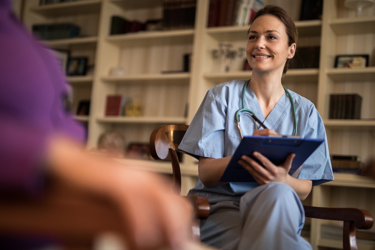 Smiling counselor listens to patient during alcohol recovery session