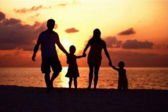 Family holding hands at sunset, symbolizing support in alcohol rehab