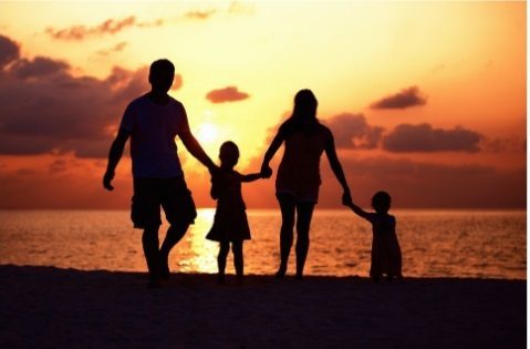 Family holding hands at sunset, symbolizing support in alcohol rehab