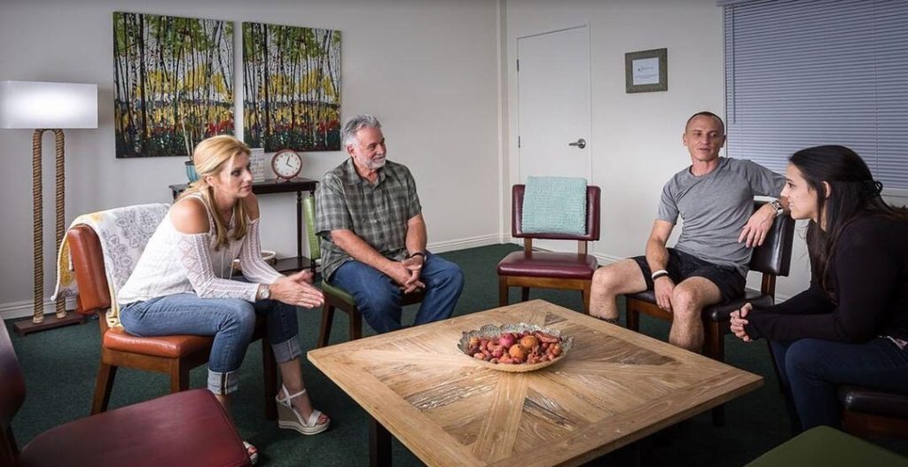 People engaging in group therapy for alcohol addiction recovery