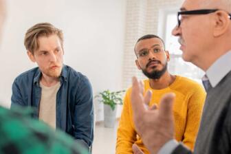 Diverse group in therapy discussing alcohol rehab and recovery