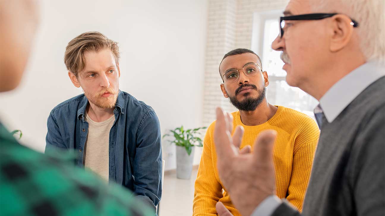 Diverse group in therapy discussing alcohol rehab and recovery