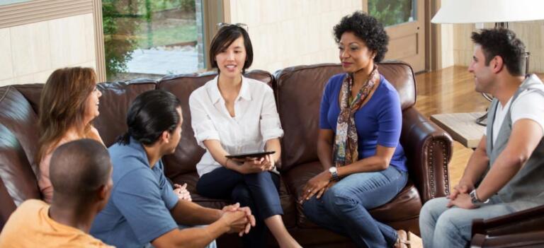 Diverse group in therapy session, discussing alcohol recovery