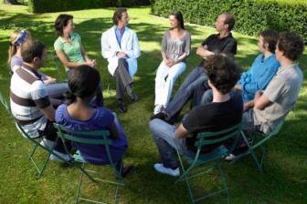 People sitting in a circle outdoors for group therapy session