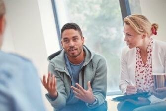 People sharing experiences in alcohol recovery group therapy session