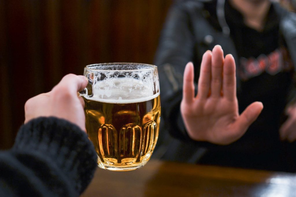 Person refusing a beer, showing determination on how to stop drinking alcohol