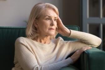 Elderly woman reflecting on losing a loved one to addiction, feeling sad