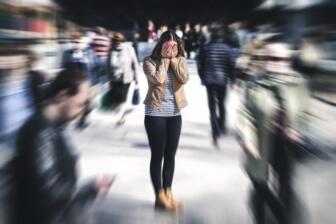 Woman feeling overwhelmed in a busy crowd, seeking alcohol recovery