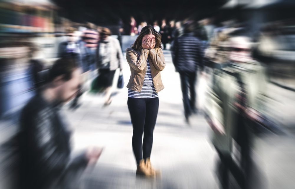 Woman feeling overwhelmed in a busy crowd, seeking alcohol recovery