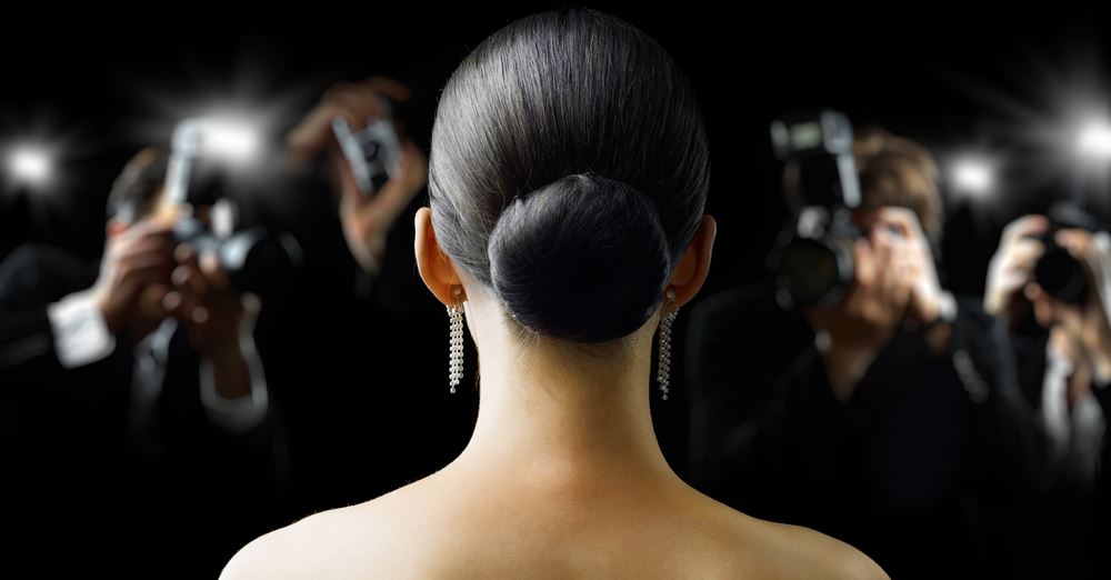 Woman facing photographers, representing pressure in alcohol recovery journey