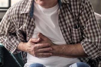 Man experiencing stomach pain from pancreatitis and alcohol