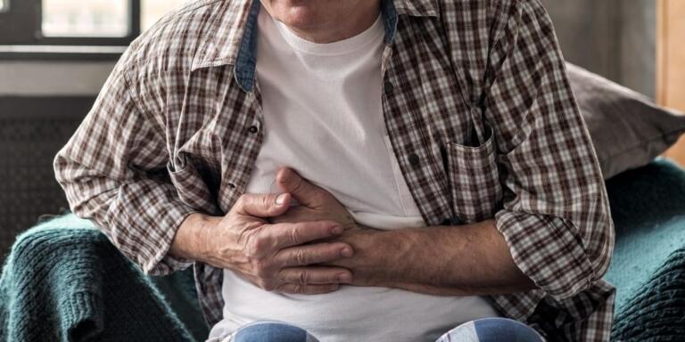 Man experiencing stomach pain from pancreatitis and alcohol
