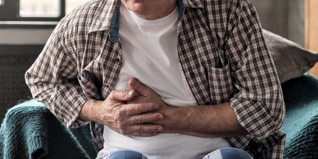Man experiencing stomach pain from pancreatitis and alcohol