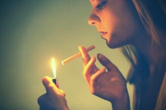 Person holds cigarette and lighter, contemplating quit smoking advice