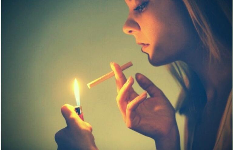 Person holds cigarette and lighter, contemplating quit smoking advice