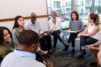 Diverse group in rehab support meeting discussing alcohol recovery