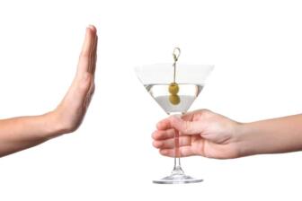 Person refusing martini to overcome alcohol addiction