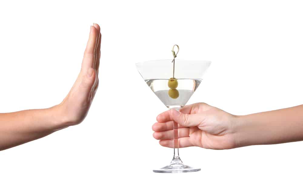 Person refusing martini to overcome alcohol addiction