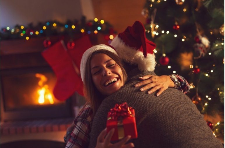 People hugging by a Christmas tree, enjoying a sober Christmas celebration.