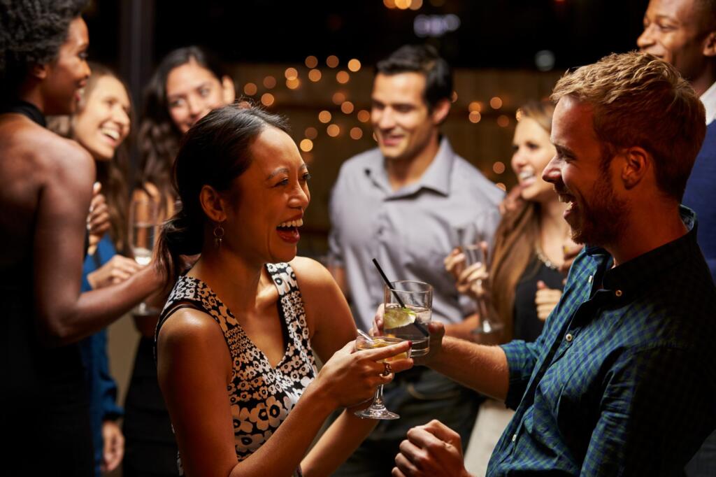 Group of friends laughing and talking at a social event without alcohol