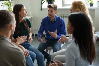 People in a supportive group therapy session for alcohol recovery.