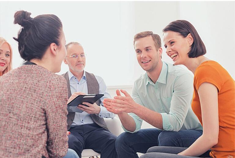 People in a supportive group therapy session discussing alcohol recovery
