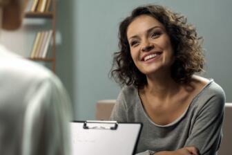 Smiling woman in therapy session for alcohol rehabilitation support