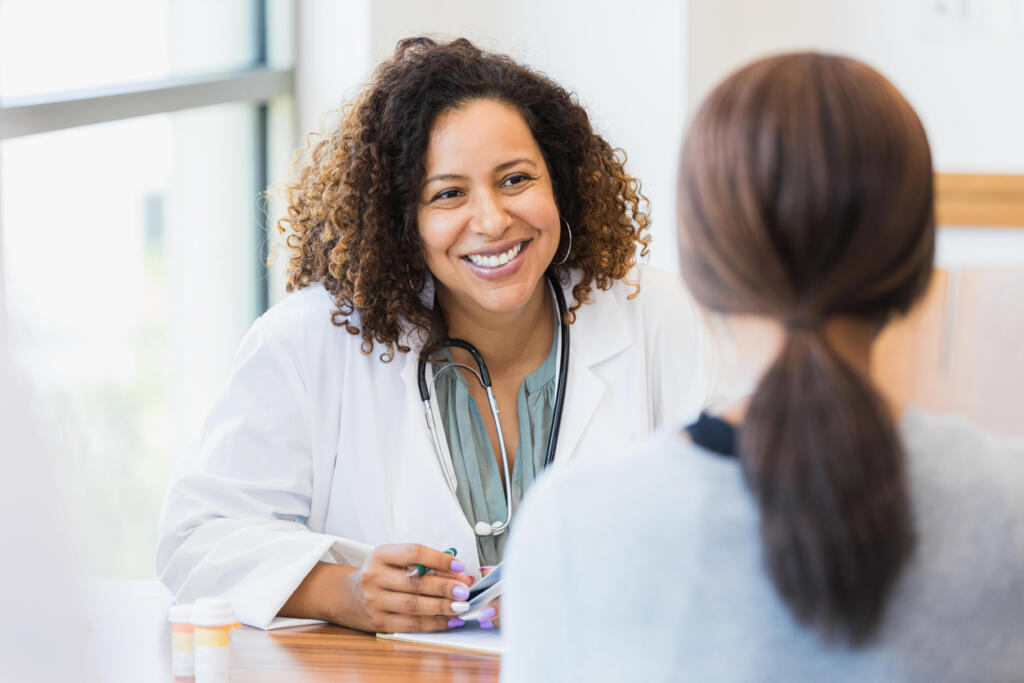 Doctor discusses treating alcoholism with a patient in rehab