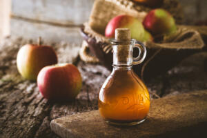 Apple cider vinegar bottle with apples promoting vitamins for alcohol withdrawal