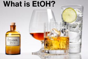 Image of whiskey, glass, lime, and ethanol bottle, illustrating what is ethanol.
