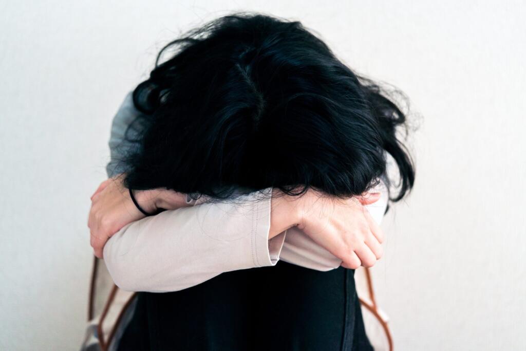 Woman in distress with head down, seeking alcohol recovery support